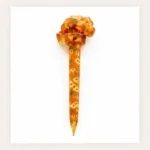 Warm amber mustard resin hair stick with an intricate floral pattern and sculpted knot top for buns