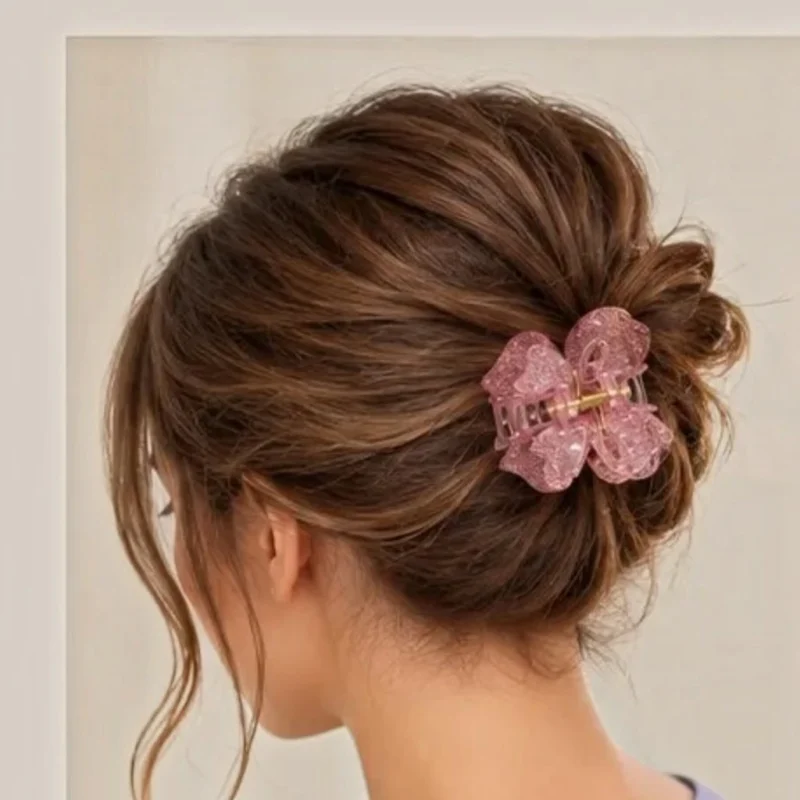 Women wearing Soft rose quartz pink resin butterfly hair claw clip with delicate glitter flecks